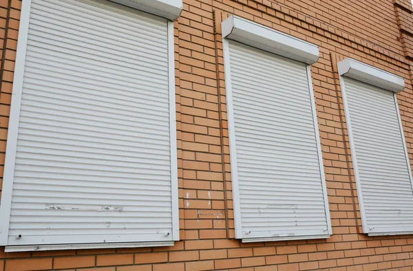 Maison en brique avec volets roulants métalliques sur les fenêtres pour la protection — Photo