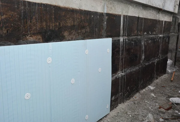 Expanded Polystyrene (EPS) foam board insulation. Rigid foam sheathing insulation on house foundation wall.