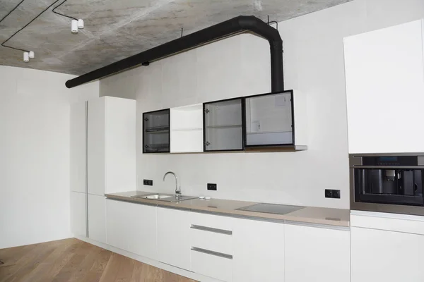 Kitchen table with hood, induction cooktop, sink, faucet in  modern kitchen.