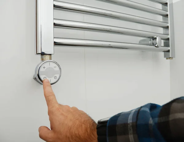 Interruptor de hombre en radiador eléctrico de toalla. Elementos de calefacción del radiador de toallas. Toallero eléctrico termostático en baño . — Foto de Stock