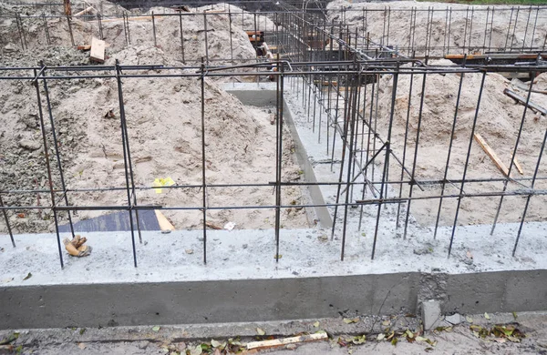 Building the brick house concrete foundation with a rigid structure of reinforcing iron bars.