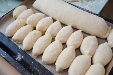 Fırını pişirmeden önce fırında pişmemiş roller, çörekler ve büyük haşhaş tohumu rulosu..