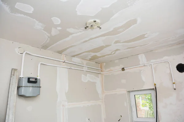 Joint taping drywalls with a compound, using drywall tape during the renovation of the kitchen.