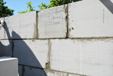 Otoklavize edilmiş beton bloklardan yeni bir ev duvarı inşa etmek.
