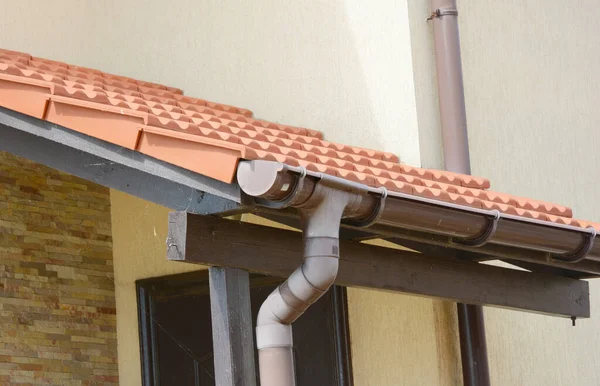 入り口のドアの上に茶色の屋根のガッタシステムと粘土タイル張りのセラミックタイル張りの屋根 — ストック写真