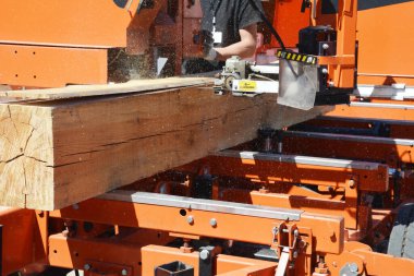 Ahşap kütükleri kereste ve tahtalara dönüştüren modern ekipmanlı kereste değirmeni makinesine yakın çekim..