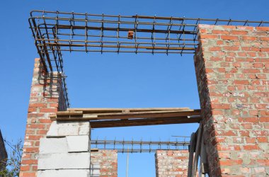 Tuğla duvar inşaatında tel çubukla pencereyi güçlendiren beton parmaklıklar.. 