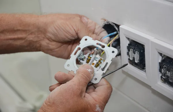 一位电工正在安装 添加新的电源插座 连接电源插座 同时在家中整修 — 图库照片