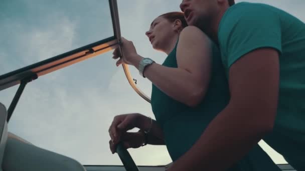 Rote Haare Mädchen im türkisfarbenen Kleid fahren Motorboot mit Mann. Liebespaar — Stockvideo
