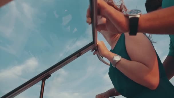 Glückliches Mädchen im türkisfarbenen Kleid fährt Motorboot mit Mann. romantisches Paar. Sonnenuntergang — Stockvideo