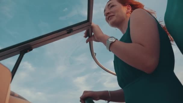 Chica joven feliz en vestido de color turquesa unidad de barco a motor con el hombre. Pareja romántica — Vídeos de Stock