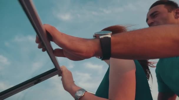 Uomo aiutare ragazza capelli rossi in abito turchese guidare barca a motore. Appuntamento romantico . — Video Stock