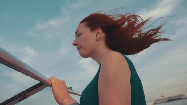 Hübsche Mädchen mit roten Haaren auf Motorboot. Sommerwindiger Abend. Sonnenuntergang. blauer Himmel. — Stockvideo