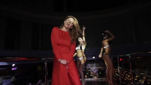 Meisje in de rode jurk dansen op stand op party in discotheek. Handen te verhogen. Go-Go. — Stockvideo