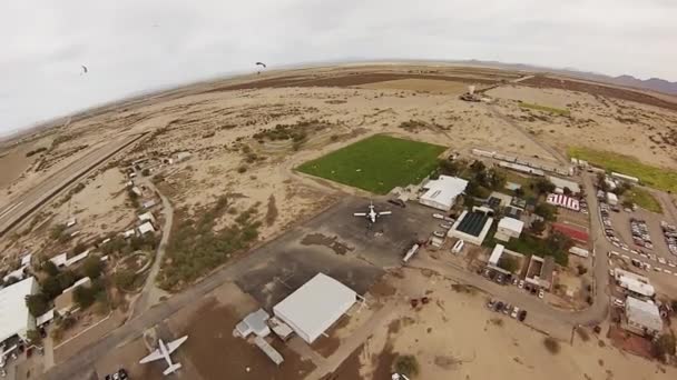 Fallskärmshoppare Fallskärmshoppning i himlen ovanför sanden i Arizona. Extrem sport. Landning. — Stockvideo