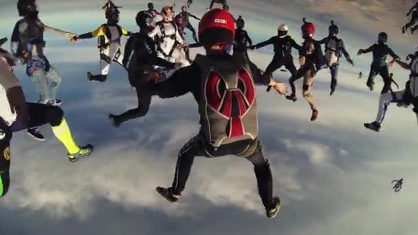 RAVENNA, ITALIA - 2 GIUGNO 2014: Molti paracadutisti fanno figura nel cielo serale nuvoloso. Estrema. Si tiene per mano. acrobazie — Video Stock