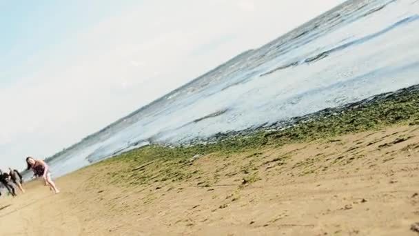 Chica joven y feliz corriendo en la playa, saltar sonrisa en la cámara. Día soleado. Mar. — Vídeo de stock