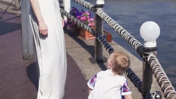 Madre en vestido de noche con su hijo pequeño en la terraza en el río. Evento. Verano . — Vídeo de stock