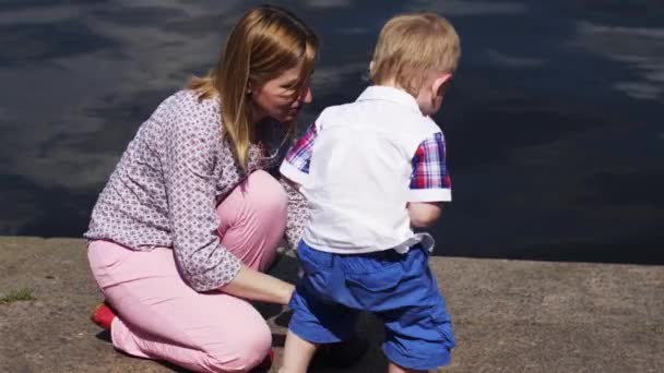 Mutter mit kleinem Sohn in blauer Hose am Meer. Veranstaltung. Sommersonniger Tag. Wasser — Stockvideo