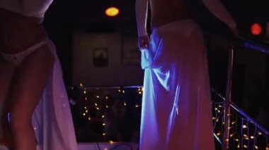 İki gece kulübünde standında beyaz bikini dalga ganimet kızlar gidin. Yüksek topuklu.