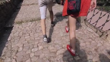 Barcelona, İspanya - 7 Haziran 2015: kız ve erkek yürüyüş tarafında tuğla yolda geri. El kask. Seyahat. Turistler. Ziyaret etti