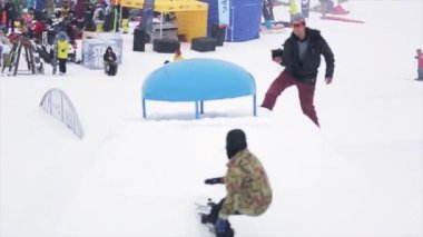 Soçi, Rusya - 29 Mart 2016: Snowboardcu kicker üzerinden atlamak, dağlarda kayak merkezinde havada ters çevirin. Ekstrem sporlar. Kameraman