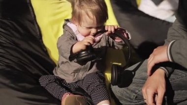 Saint Petersburg, Rusya - 16 Temmuz 2015: Küçük defne kızı kulaklıkla beanbag oynamak oturup, gülümseme. Yaz rüzgarlı bir gün. Açık hava festivali