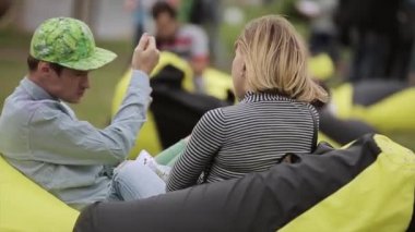 Saint Petersburg, Rusya - 16 Temmuz 2015: Erkek ve sarı ve siyah puf Yaz Festivali üzerinde oturan kız. Eğlence. Güneşli gün