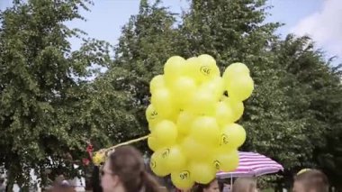Saint Petersburg, Rusya - 16 Temmuz 2015: Genç sarışın kız yaz festivalinde kasetlerde birçok sarı hava balonu tutuyor. Güneşli bir gün. Eğlence