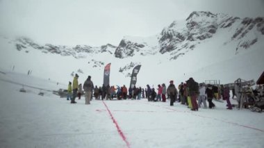 Soçi, Rusya - 31 Mart 2016: Snowboarder atar ayakkabı mesafe yamaç, karlı iz, içine kamera ile kız var. Rekabet