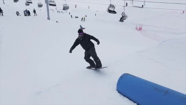 SOCHI, RUSIA - 29 DE MARZO DE 2016: Deslizamiento de snowboarder sobre trampolín, voltee en pendiente. Estación de esquí en las montañas. Desafío. Gente . — Vídeos de Stock
