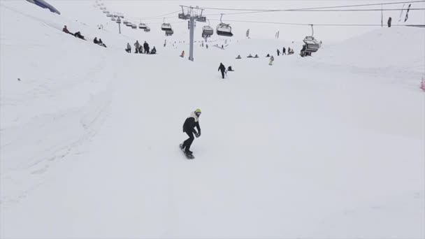 SOCHI, RUSIA - 29 DE MARZO DE 2016: Deslizamiento de snowboarder sobre trampolín en estación de esquí de montaña. Voltereta extrema. Desafío. Gente — Vídeos de Stock