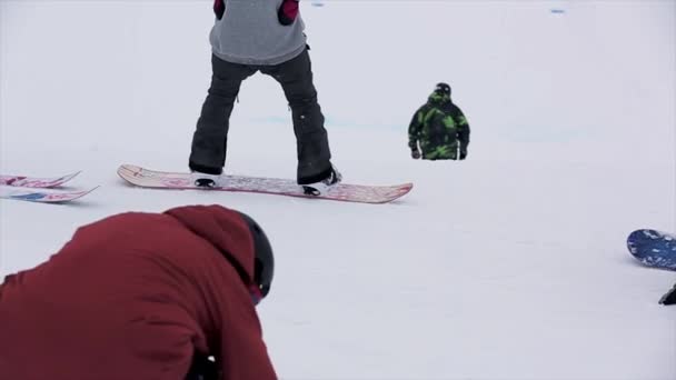 SOCHI, RUSSIA - 29 MARZO 2016: Gli snowboarder in uniforme si preparano a scendere sul pendio. Montagne innevate. Gente. Località sciistica — Video Stock