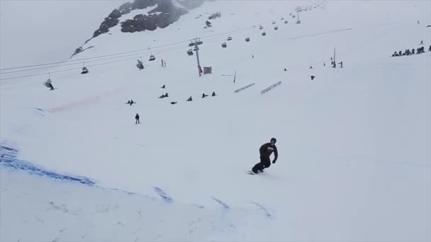 Soczi, Rosja-29 marca, 2016: Snowboarder skok z trampoboard na stoku, Flip, chwycić w powietrzu. Ośrodek narciarski w górach. Wyzwanie. — Wideo stockowe