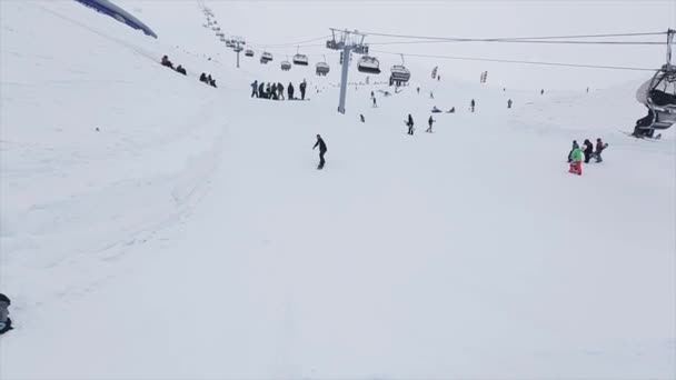 SOCHI, RUSIA - 29 DE MARZO DE 2016: Snowboarder hace voltear el trampolín en la pendiente. Estación de esquí en las montañas. Desafío. Gente. Remontes — Vídeo de stock