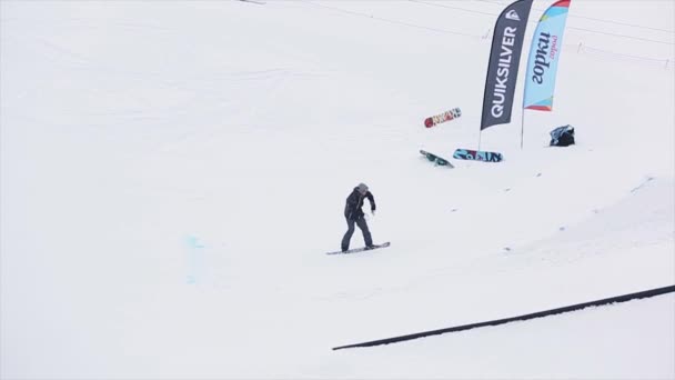 SOCHI, RUSSIA - 29 MARZO 2016: Snowboarder in uniforme salta dal trampolino, full flip in air. Montagne innevate. Concorso. Estremo — Video Stock