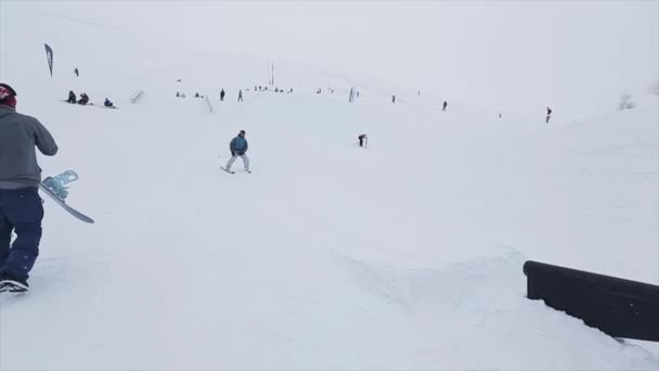 SOCHI, RUSIA - 29 DE MARZO DE 2016: Paseo en trampolín en pendiente, fallando. Estación de esquí en montañas nevadas. Desafío. Gente — Vídeos de Stock