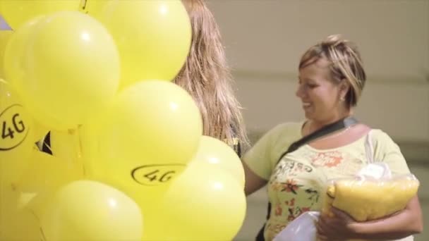 SAN PETERSBURG, RUSIA - 16 DE JULIO DE 2015: Chica rubia con muchos globos amarillos festival de verano. Día soleado. Entretenimiento. Gente — Vídeos de Stock