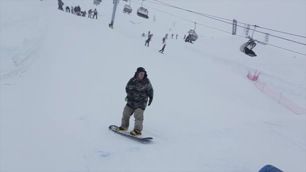 SOCHI, RUSSIA - marts 29, 2016: Snowboarder hoppe fra springbræt på skråning, 360 flip. Skisted i sneklædte bjerge. Svigt . – Stock-video