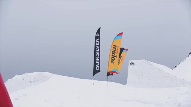 SOCHI, RUSIA - 29 DE MARZO DE 2016: Salto snowboarder desde trampolín. Paisaje de montañas. Niebla. Concurso. Banderas. acrobacias peligrosas — Vídeos de Stock
