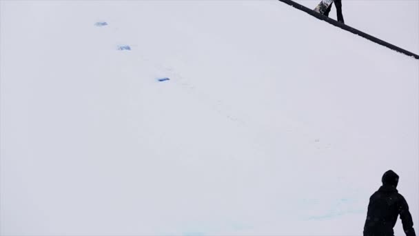 Sochi, Oroszország-március 29, 2016: Snowboarder ugrani ugródeszka a sípálya, flip a levegőben. Havas hegyek. Táj. Emberek — Stock videók