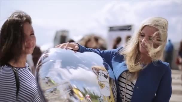 Sint-Petersburg, Rusland-16 juli 2015: twee aantrekkelijke meisjes met lucht ballon poseren voor foto op zomer Festival. Wind. Entertainment. — Stockvideo