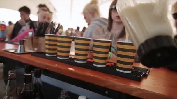 Sint-Petersburg, Rusland - 16 juli 2015: Barman pour cocktail in glazen met strip op straat bar op zomerfestival. Zonnige dag. Mensen — Stockvideo