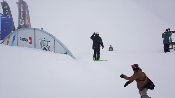 SOCHI, RÚSSIA - MARÇO 29, 2016: Snowboarder back slide on iron curved trail at ski resort in mountains. Extremo. Concurso. Desafio — Vídeo de Stock