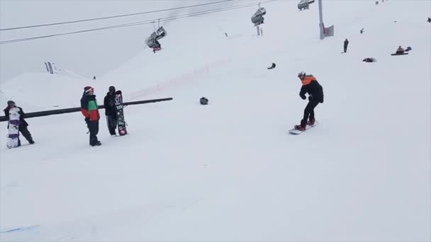 Soczi, Rosja-29 marca, 2016: Snowboarder jeździć na szlaku żelaza na stoku. Ośrodek narciarski w ośnieżonych górach. Wyzwanie. Ludzi. Stunt — Wideo stockowe