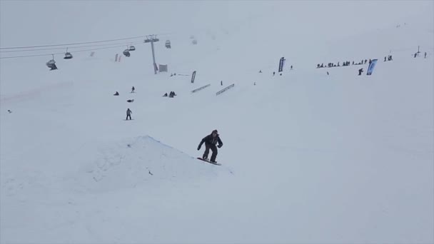 SOCHI, RUSSIA - marts 29, 2016: Snowboarder hopper fra springbræt på skråning, 360 flip, gribebræt. Skisted i bjergene. Udfordring – Stock-video