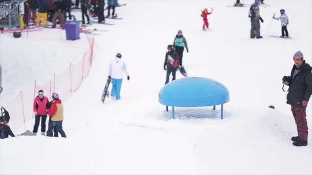 SOCHI, RÚSSIA - 29 de março de 2016: Snowboarder jump on kicker, extreme stunt at ski resort in mountains. Concurso. Acrobacias. Cameraman — Vídeo de Stock