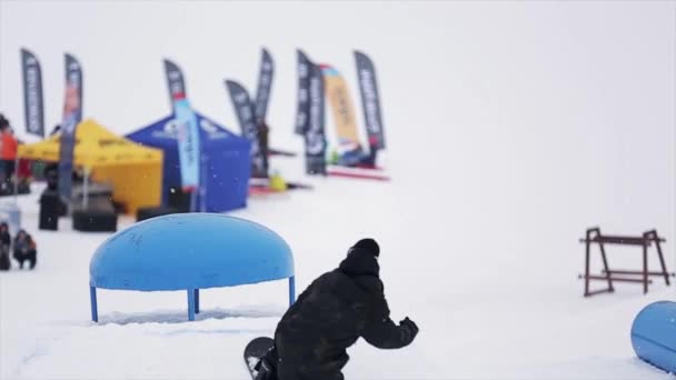 Sochi, Rusko-29. březen 2016: skok snowboardista nad kicker v lyžařském středisku v horách. Nebezpečný koníček. Lidé. Soutěž. Výzva — Stock video
