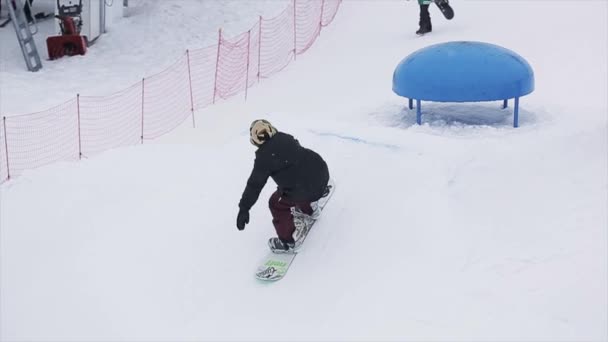 SOCHI, RUSIA - 29 DE MARZO DE 2016: Snowboarder salto en kicker hacer acrobacias en la estación de esquí en las montañas. Deporte extremo. Gente. Camarógrafo — Vídeos de Stock
