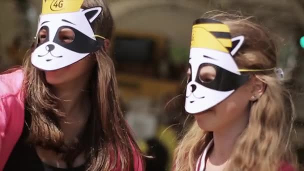 СЕНТ-ПЕТЕРБУРГ, РОССИЯ - 16 июля 2015 года: Три девочки-подростка танцуют в смешных масках на лицах на летнем фестивале. Солнечный день. Развлечения — стоковое видео